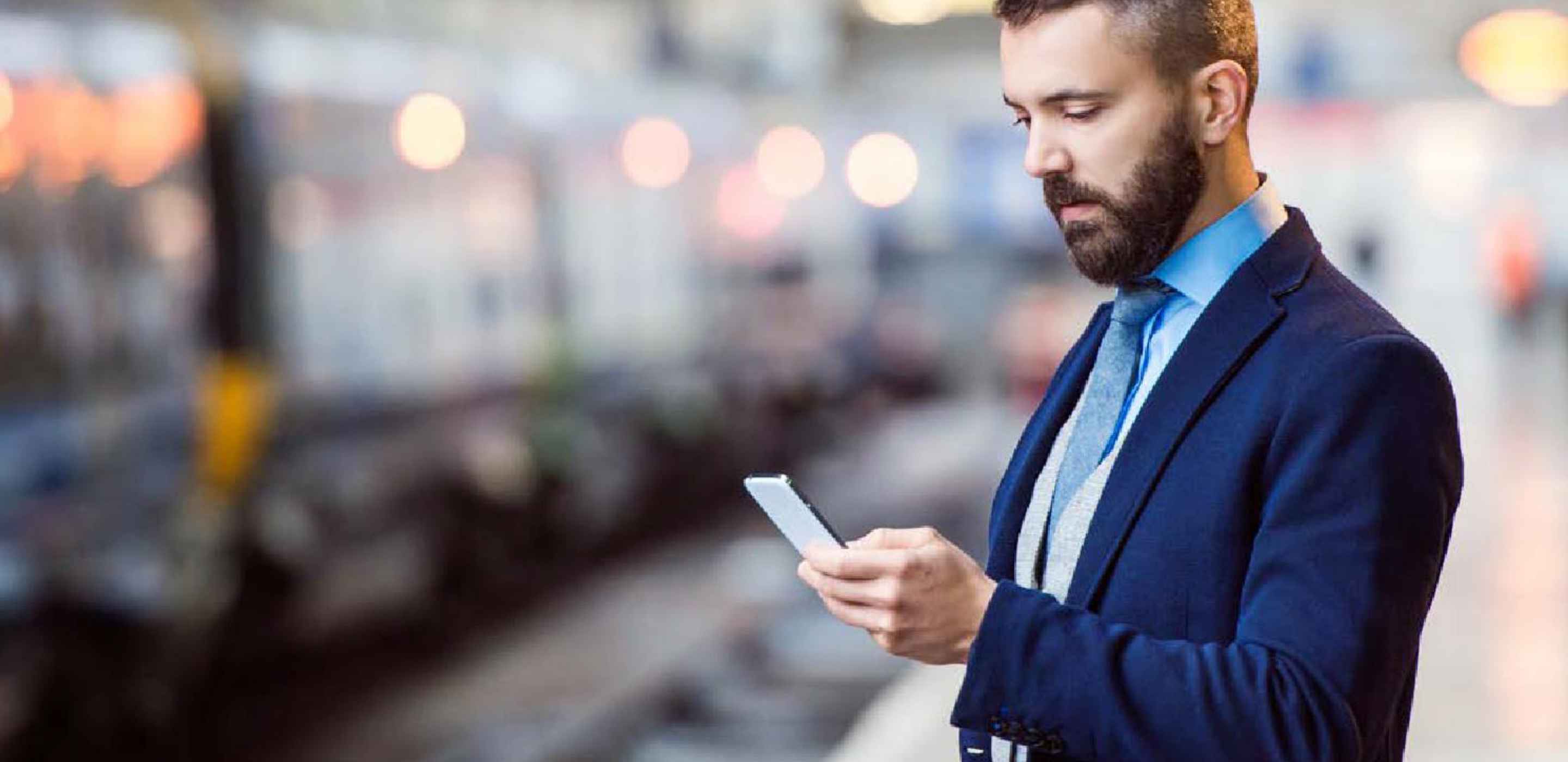 A man wearing a suit holding a cellphone