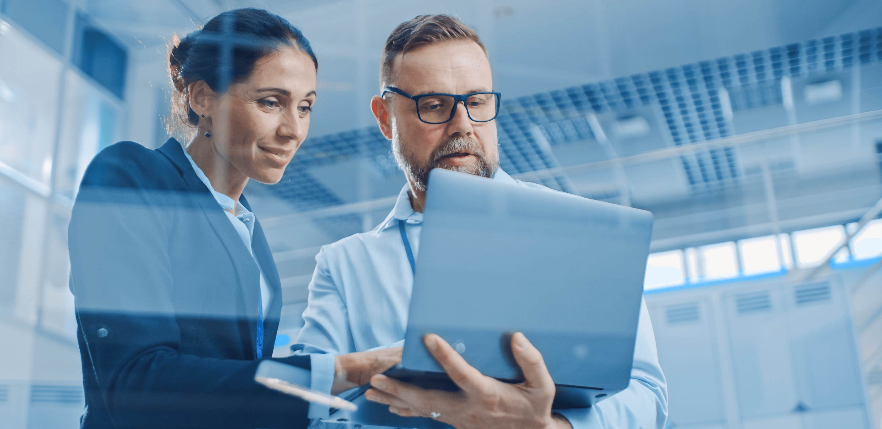 A man wearing glasses and a woman looking at laptop screen