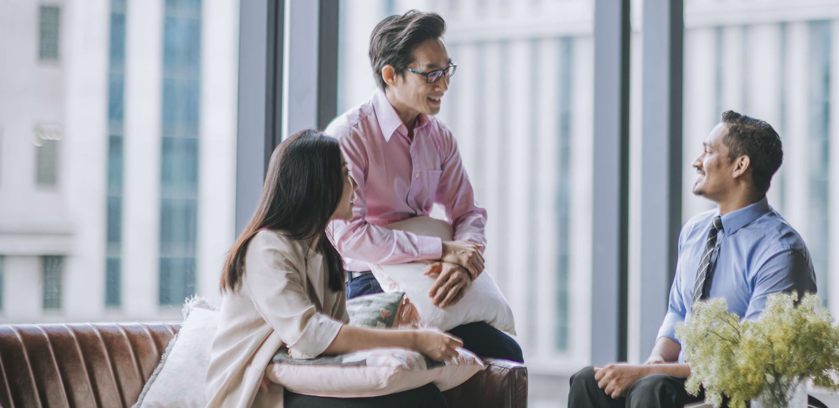 Indian male white collar worker in wheelchair discussion in office lounge with his colleague