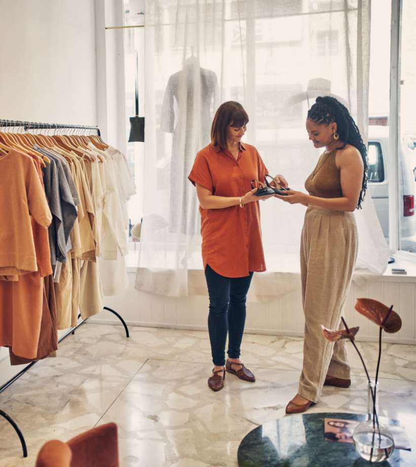 Shot of two young women looking at a pair of shoes in a clothing store