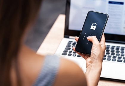 A cellphone locked screen with laptop hehind