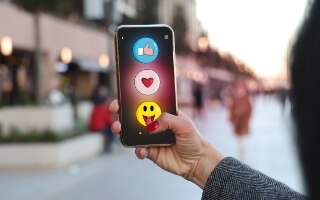 Person holding a phone with emojis