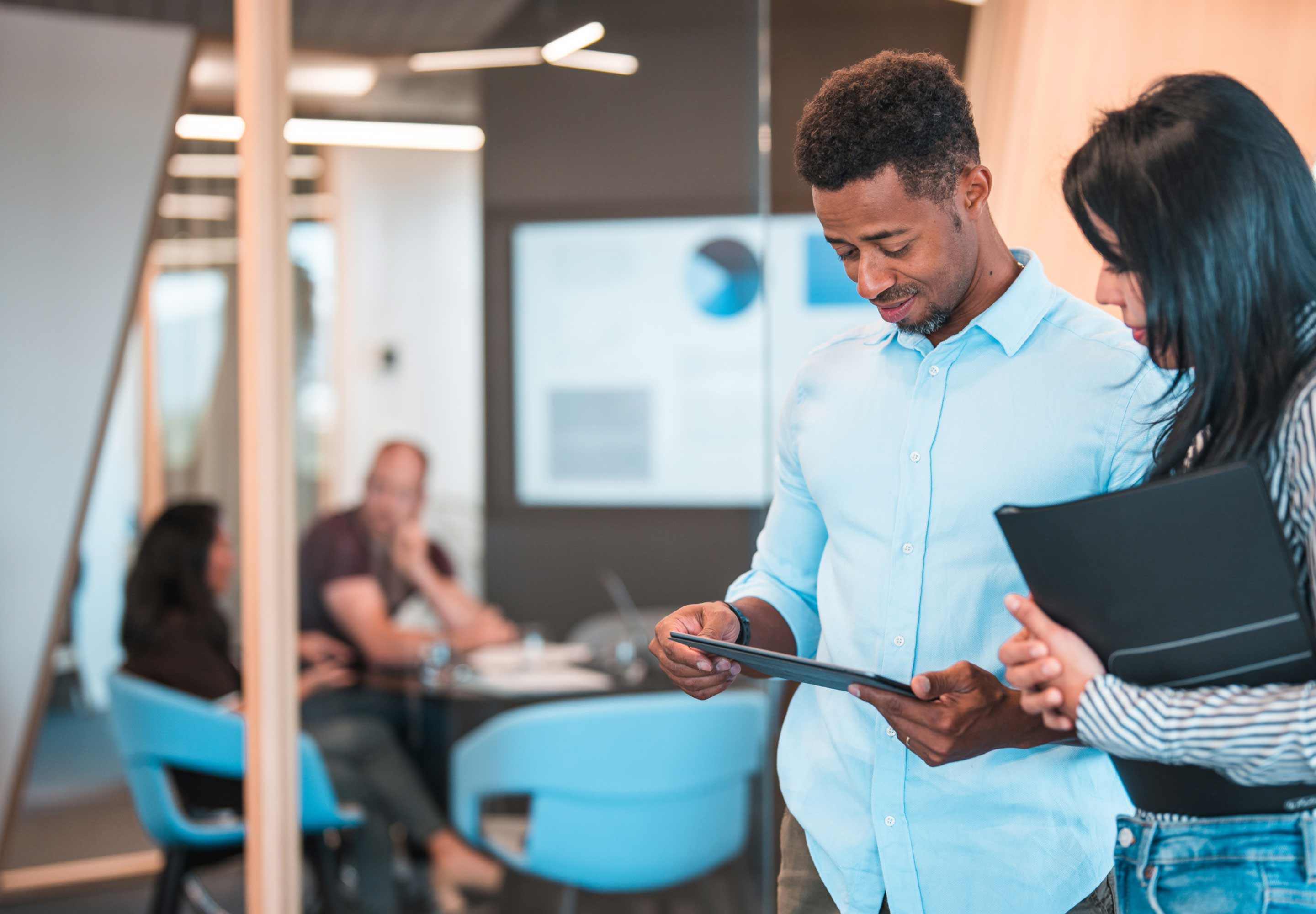 Colleagues standing in a meeting room
