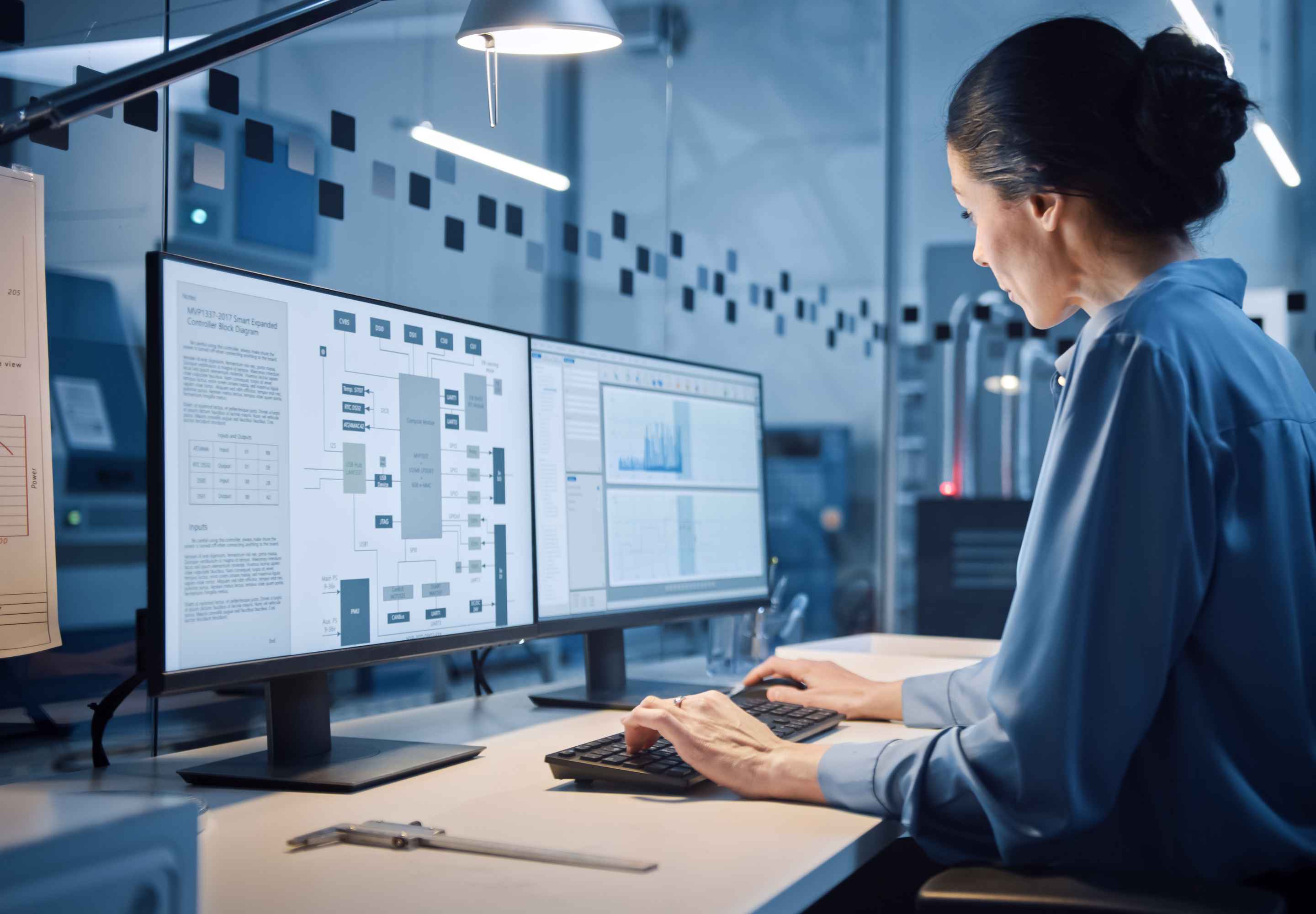 Woman working at dual monitor workstation