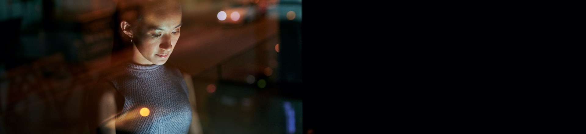 A woman working with light reflected in the window