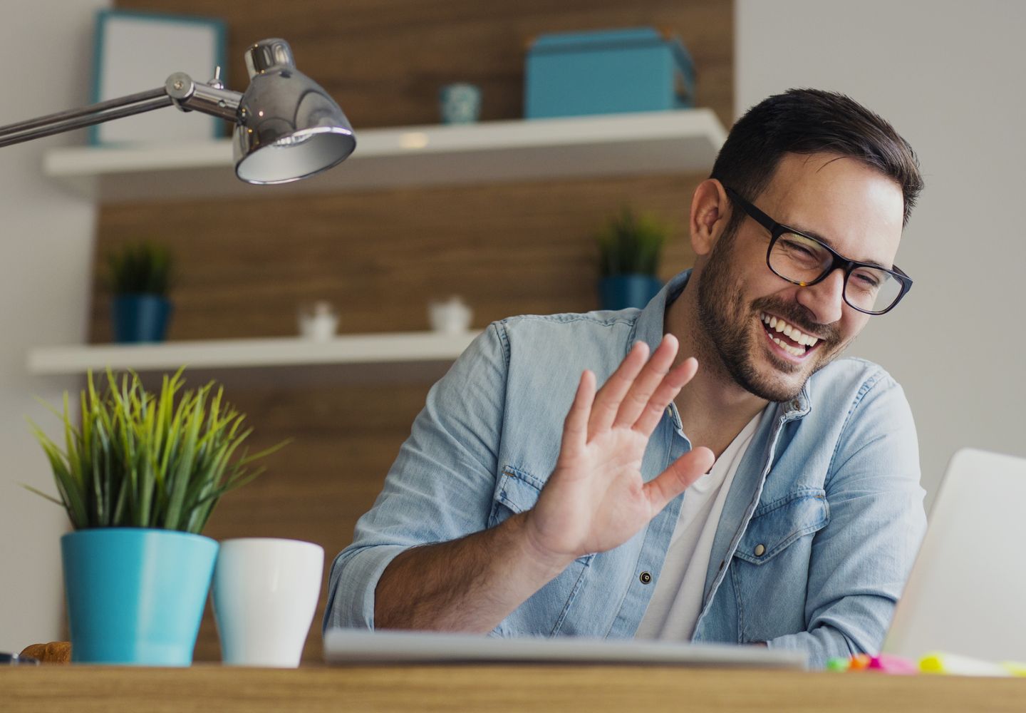 Man waving while on a conference call