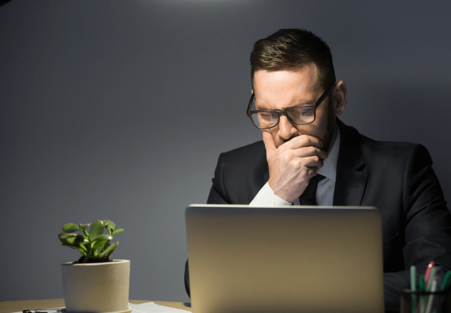 Business professional in a suit looking at the laptop screen