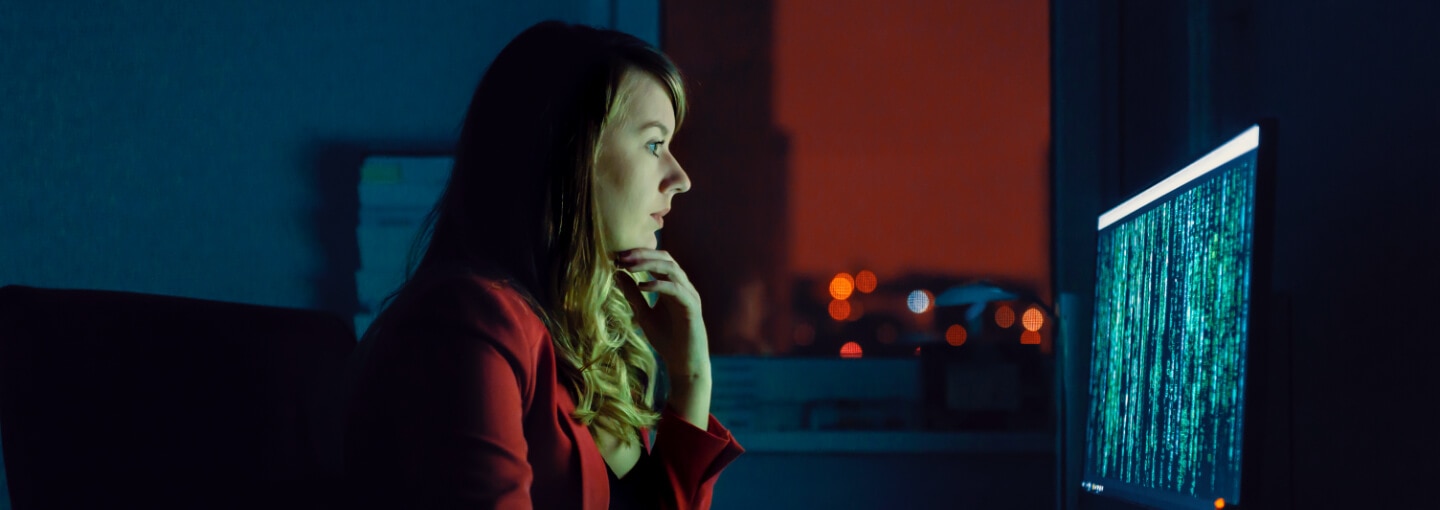 Woman looking at code running on a monitor