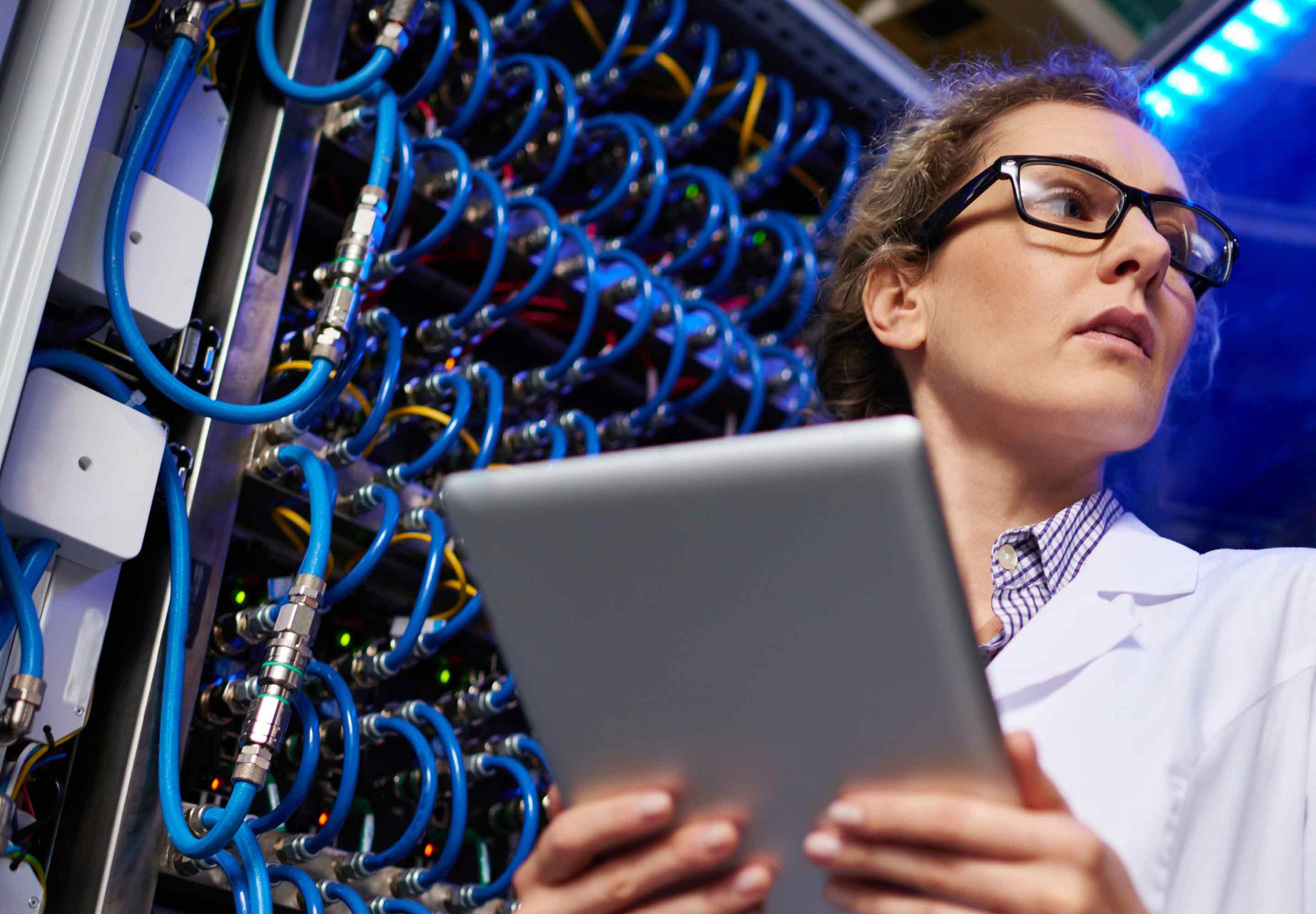 Wires lined up behind a woman holding a tablet