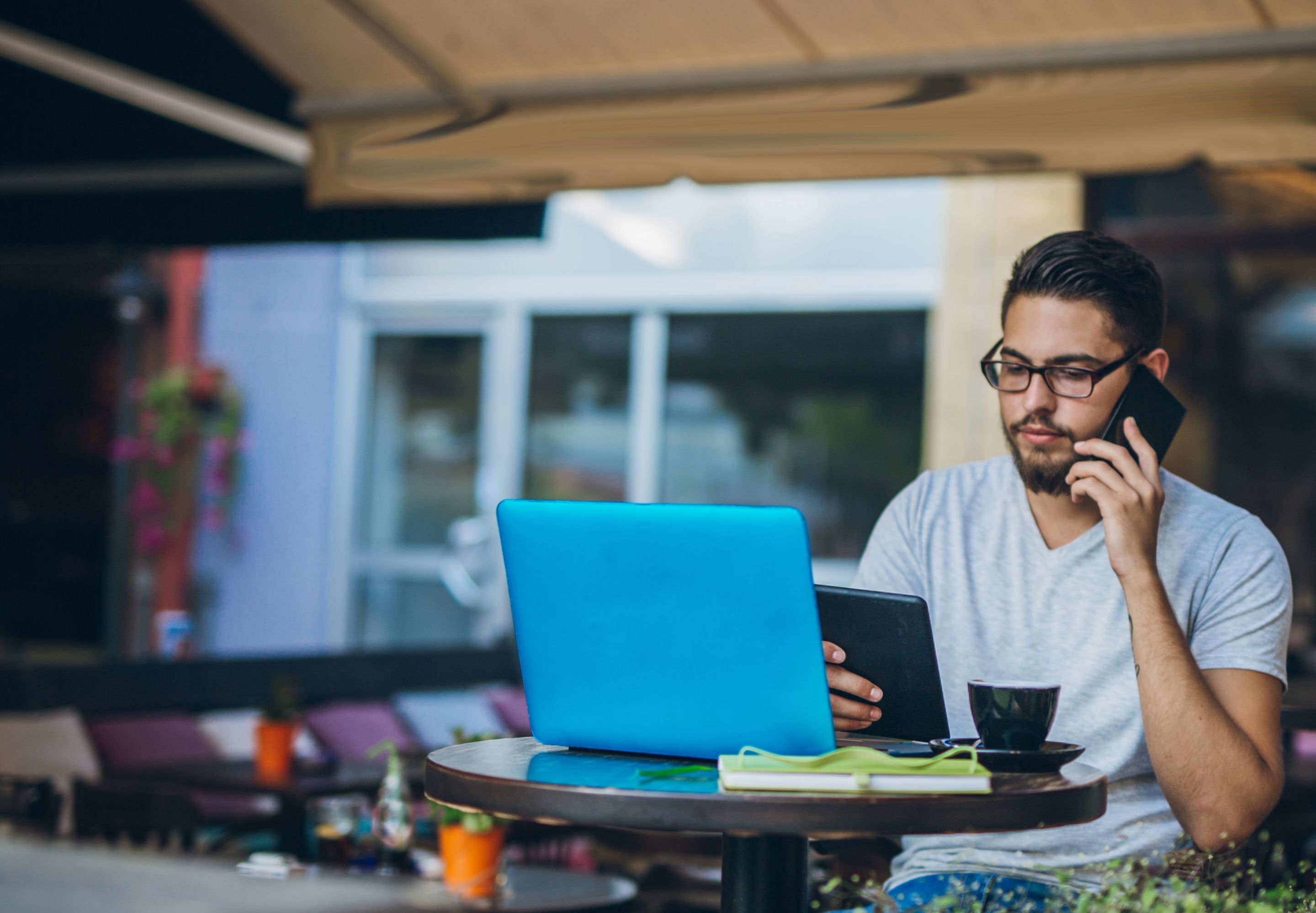Man talking on his mobile phone in front of a laptop