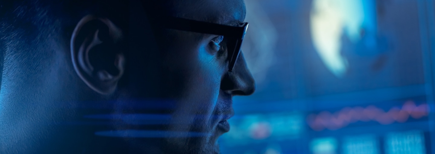 A man with glasses looking at a screen