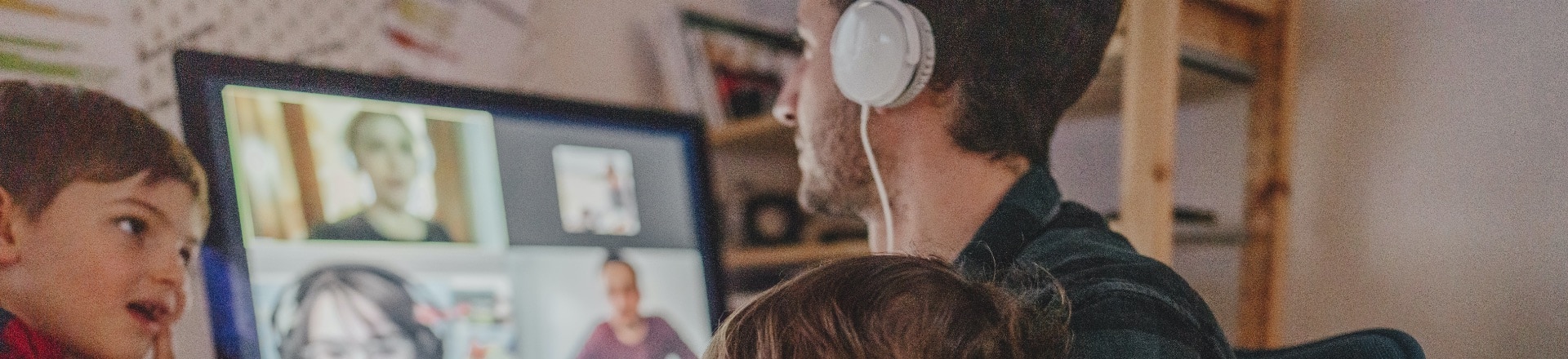 A dad on a video call with his kids around him as he works from home
