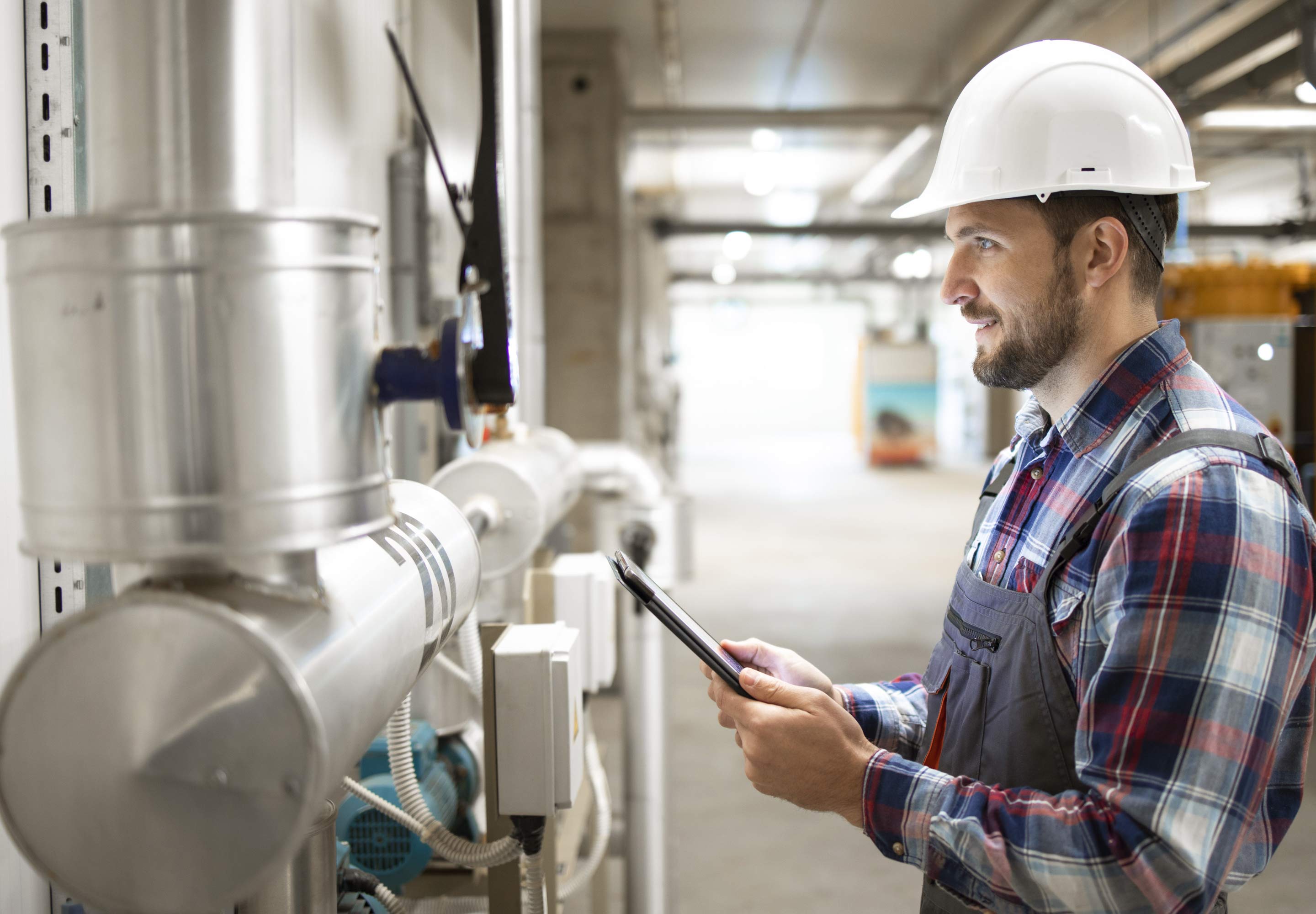 A man wearing a helmet looking at a tablet