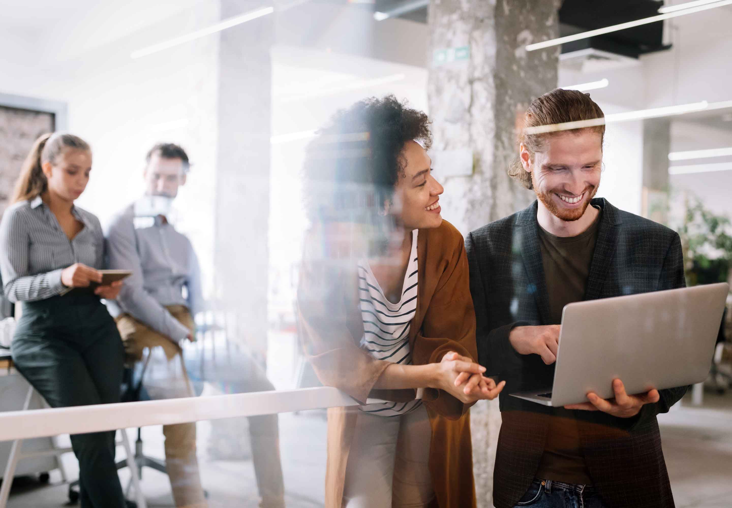 a woman and a man looking at a laptop screen