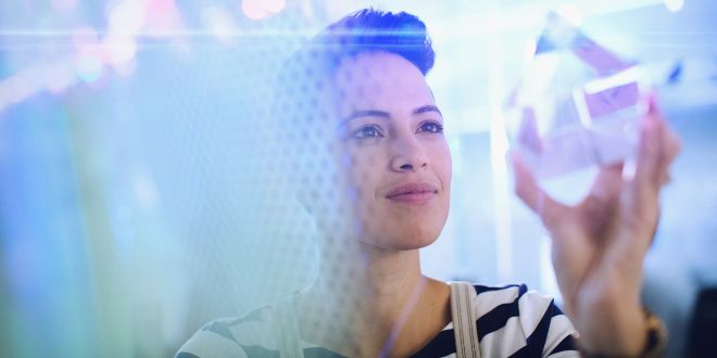 Woman looking into a glass cube