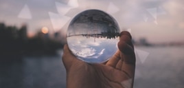 A hand holding a glass globe