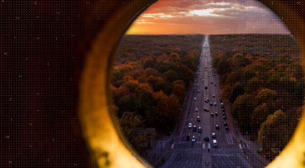 Blick durch ein kreisförmiges Fenster auf den Verkehr auf einer Autobahn