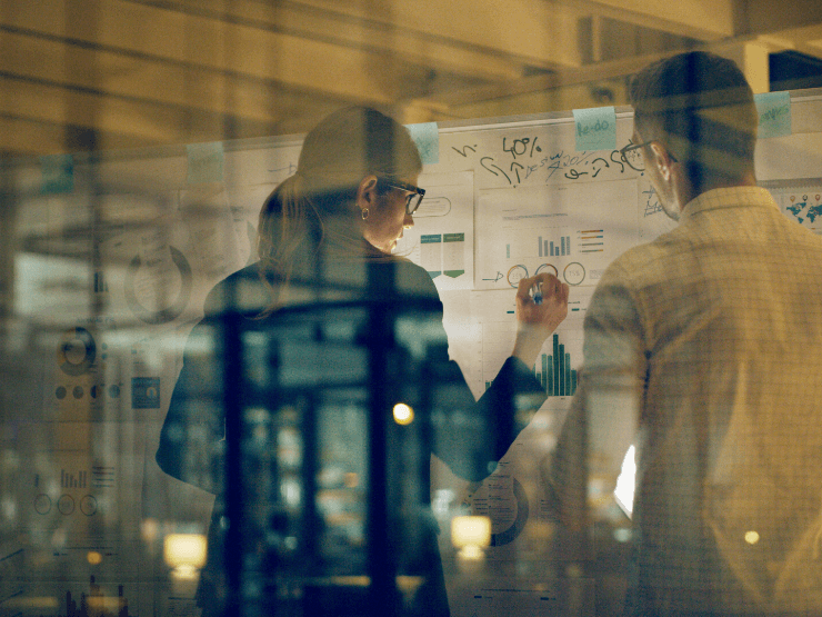 People working on a board with a reflective window