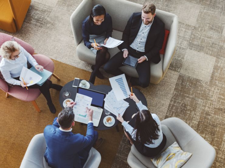 Five people sitting around a table working