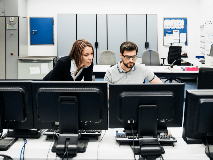 Two people sitting together in front of a monitor