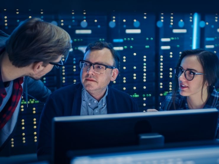 Colleagues in discussion with a server array in the background