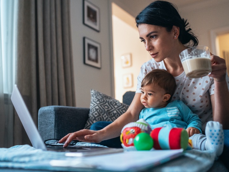 A woman working from home with her baby