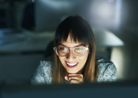 Smiling woman looking at a computer screen