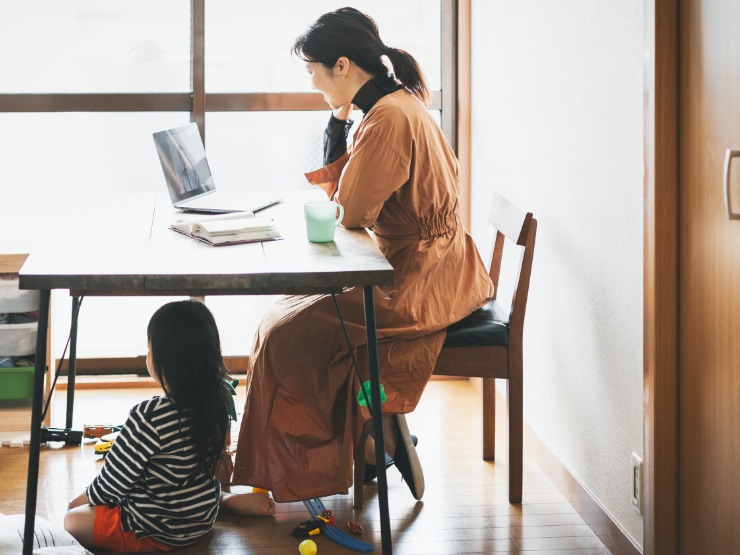 A woman working from home with her daughter