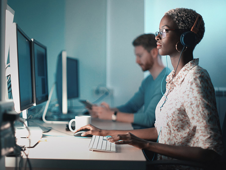 Woman wearing headphones sitting at a computer