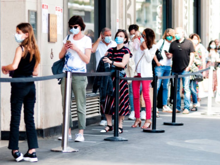 People standing in a queue with masks